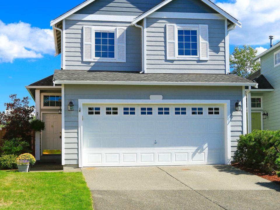 Two story house with small entrance porch and garage with driveway in Urbana, MD.
