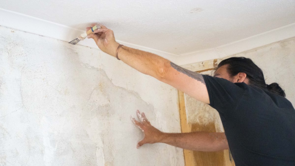 Man renovation walls plastering cracks in wall interior