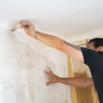 Man renovation walls plastering cracks in wall interior