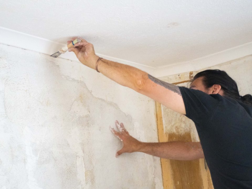 Man renovation walls plastering cracks in wall interior